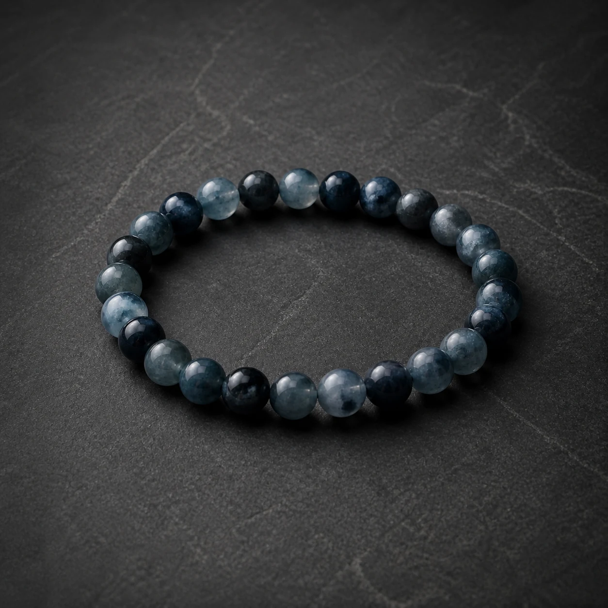 A complete low-saturation navy and smoky blue-grey custom bracelet made from round eight millimeter stone beads